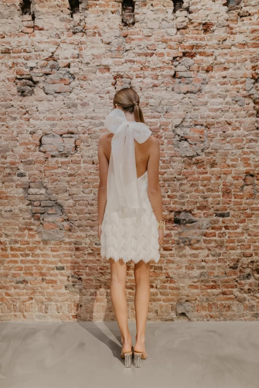 bruid met korte trouwjurk met franjes en halter voor tweede look op de bruiloft