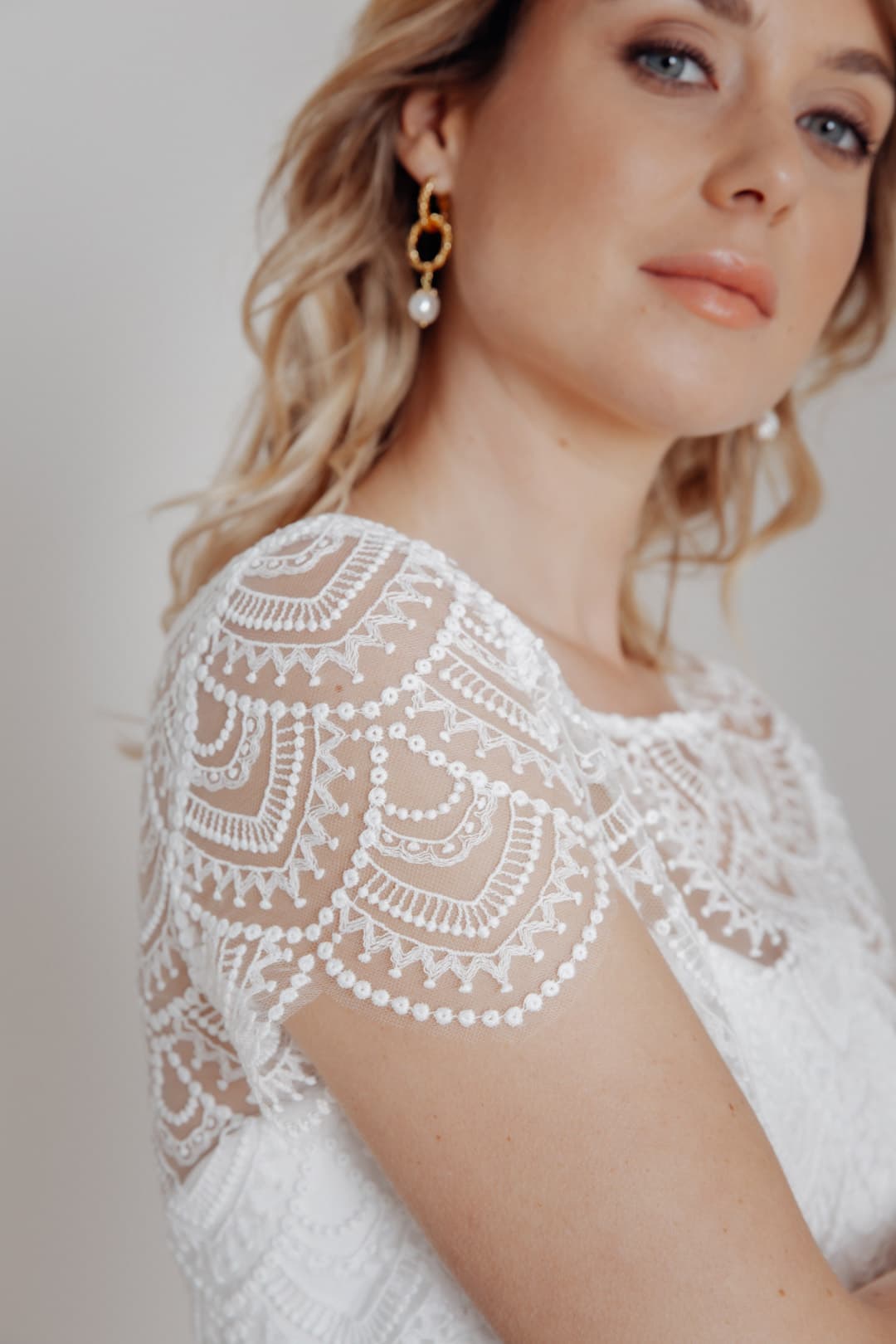 De Niah-top is een prachtig alternatief voor trouwjurken in bloemstijl of bruidsjurken. Het geborduurde patroon in vintagelook zorgt voor een originele en speelse touch zonder te kitscherig of romantisch te zijn, maar toch vrouwelijk en elegant.
Prachtig afgeronde geschulpte randen en korte mouwen zijn verdere mooie details, net als de knoopsluiting aan de achterkant voor een casual, elegante jasjelook die zorgeloze lichtheid uitstraalt, vooral op een zomerse bruiloft.

Om geen ongewenste blikken bloot te stellen, raden wij een gelaagde top aan.

Niah is grotendeels gemaakt van ecokatoen